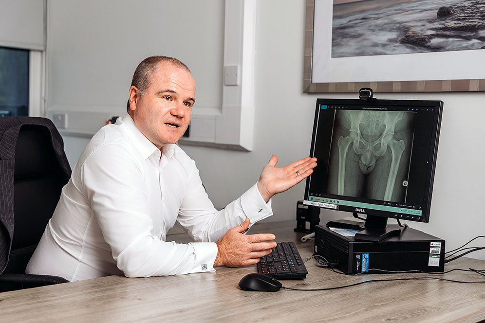 Mr Daniel Dowen discussing complex hip replacement planning during a consultation