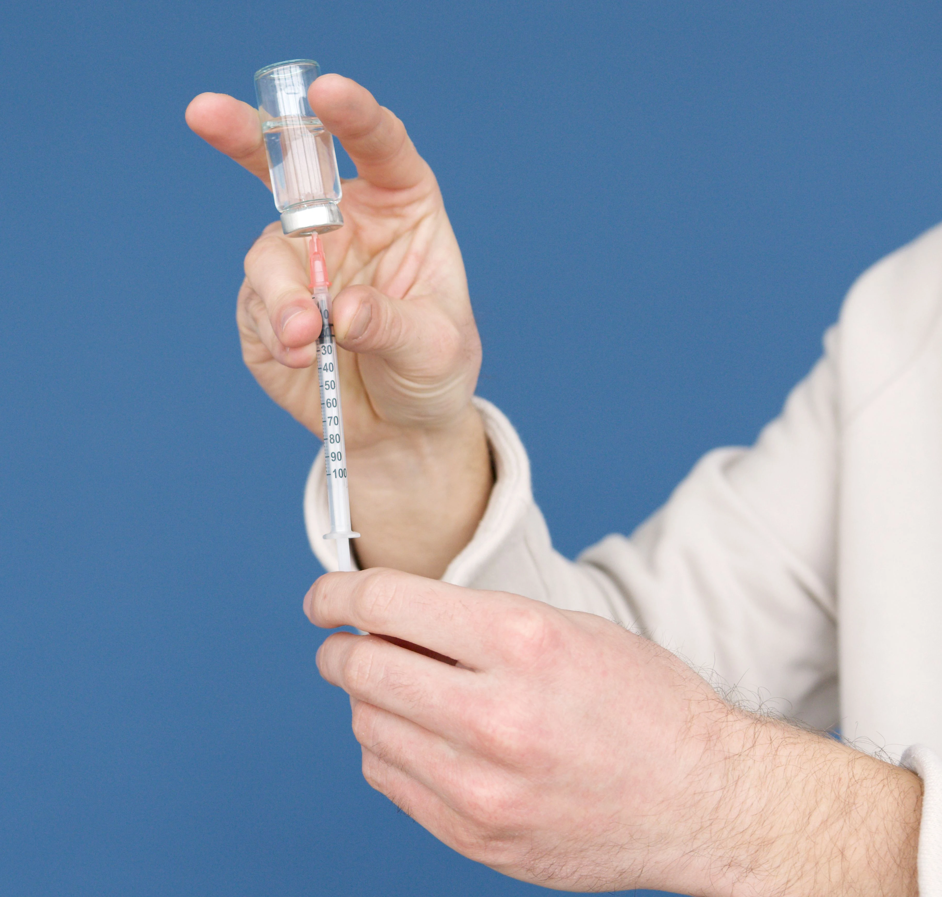 Clinician preparing a syringe for joint injection treatment